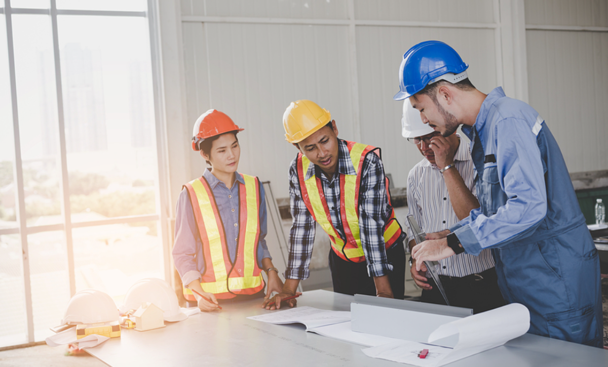 Why Commercial Buildings Need Stucco Contractors, Engineers are meeting and pointing to new construction sites, Engineering tools and construction concept.