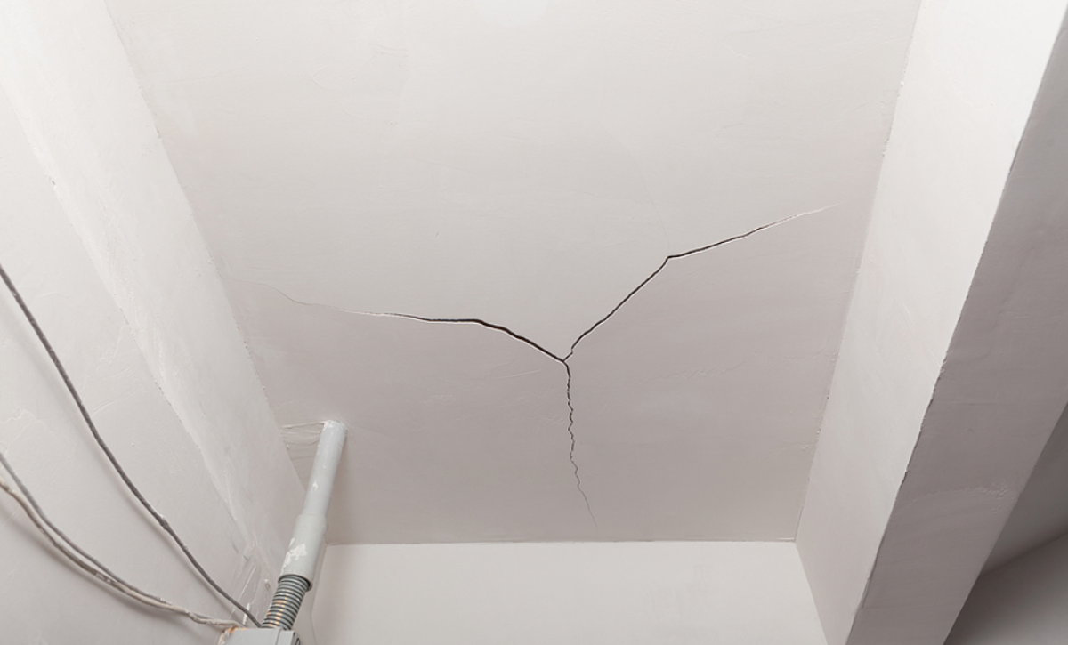 DIY stucco repair process showing homeowner patching cracks on exterior wall with stucco tools and materials