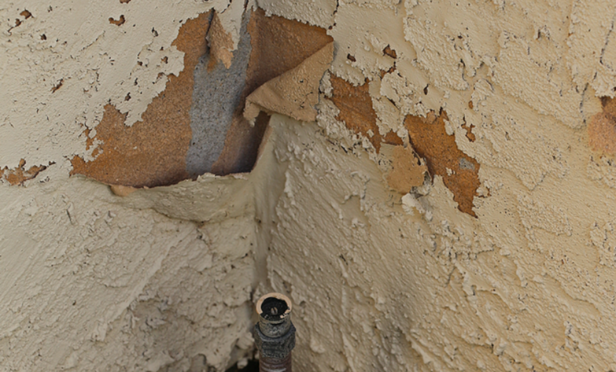 Water intrusion damage on a stucco wall showing cracks, staining, and moisture-related deterioration requiring professional stucco repair.