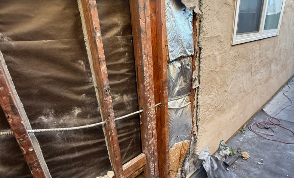 Stucco repair showing exposed wood stud framing